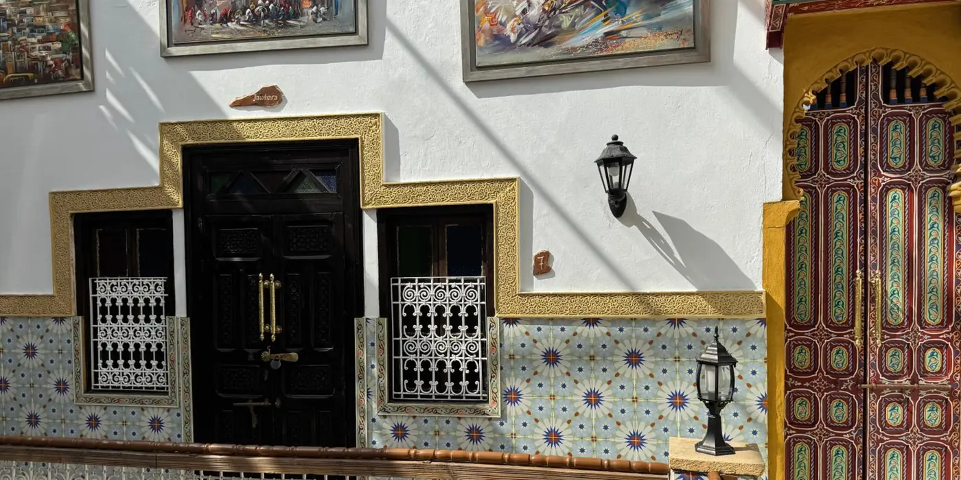 La galerie de l’étage, une porte peinte et des toiles aux murs