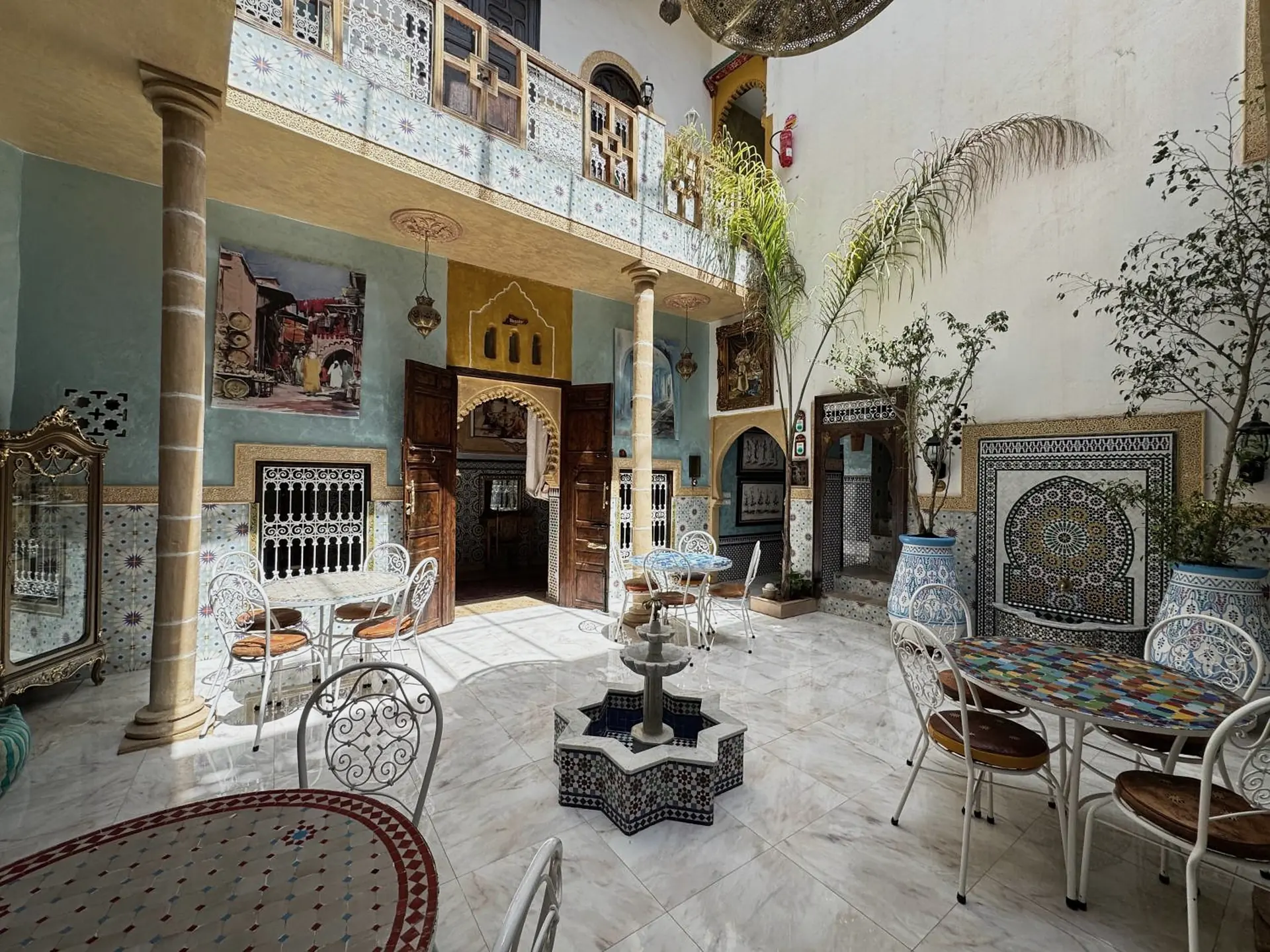 Le patio de jour, la fontaine en étoile et les tables en zellige