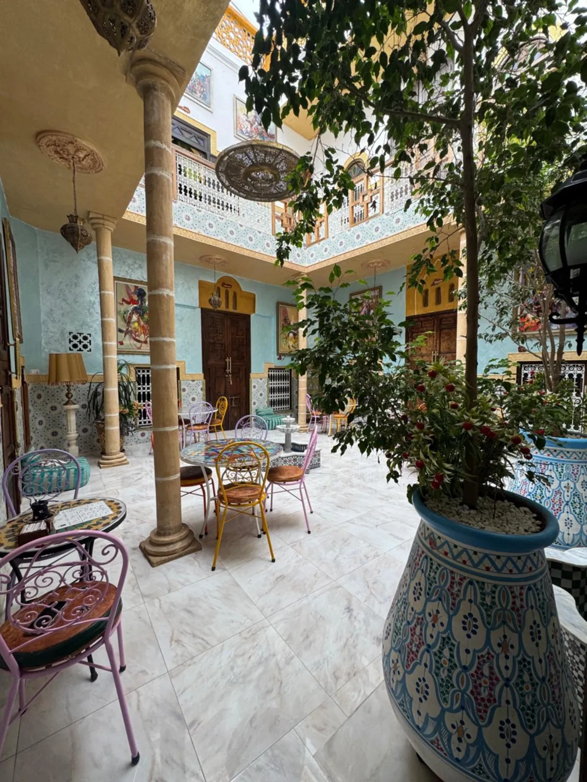 Le patio, une colonne, des tables et un arbre