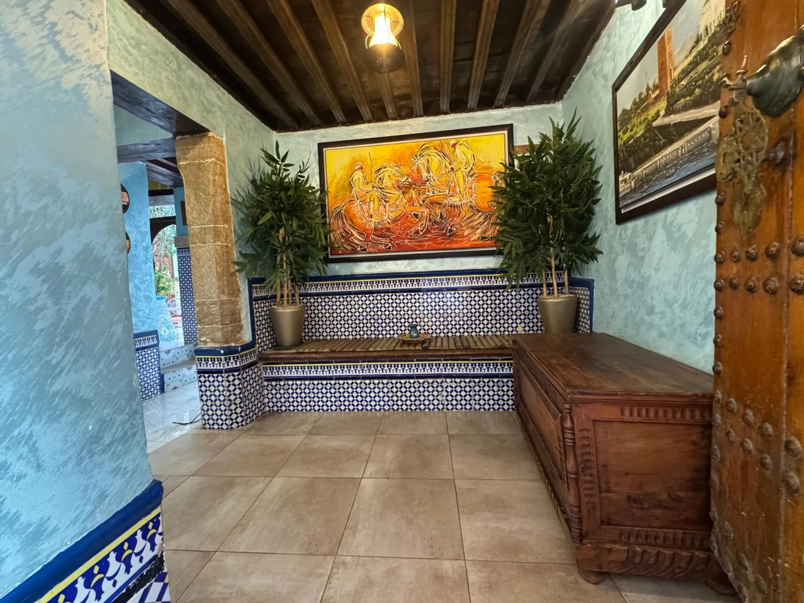 Un coin du patio, mur bleu, banquette et grande toile