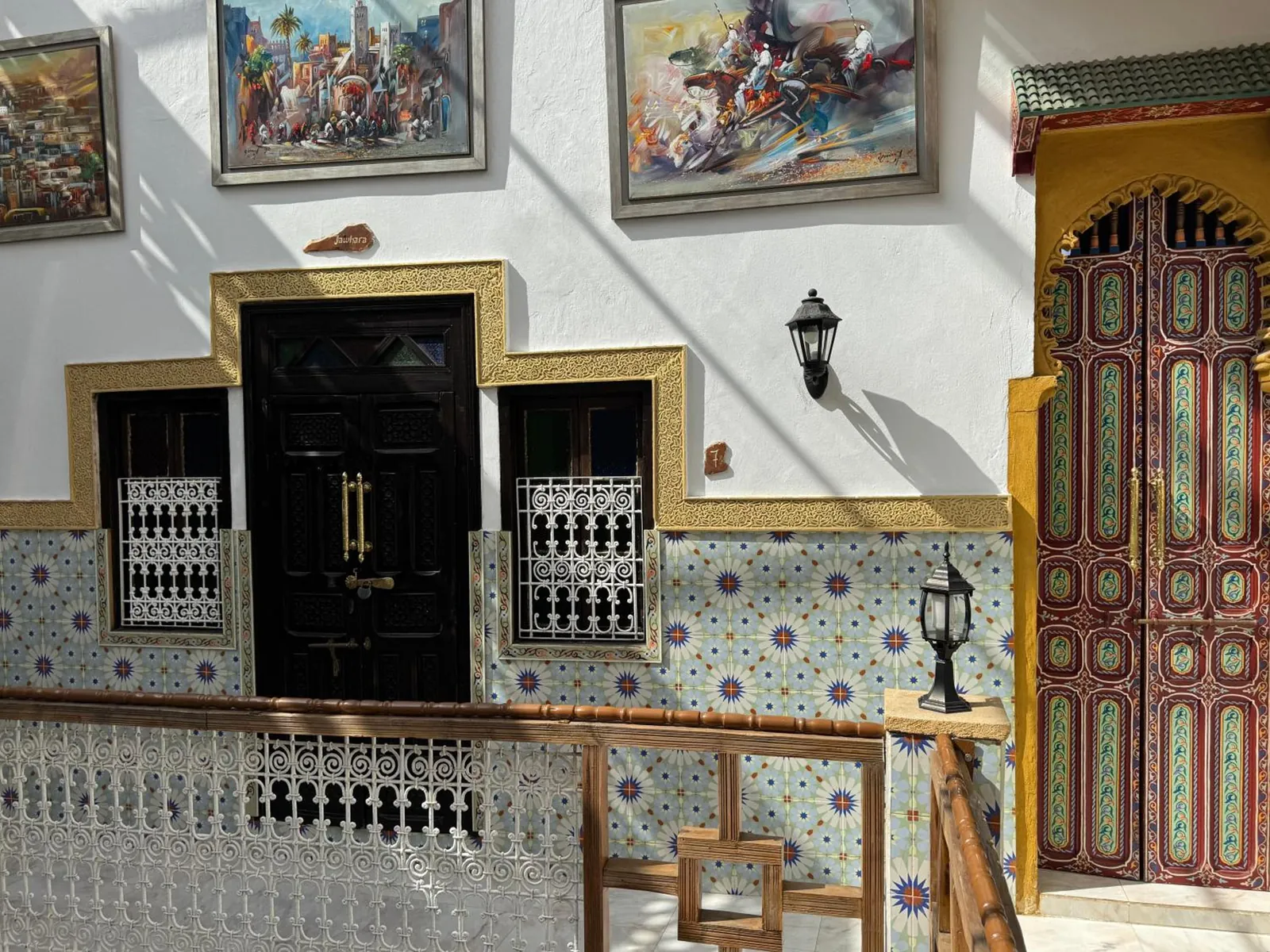 La galerie de l’étage, une porte peinte et des toiles aux murs
