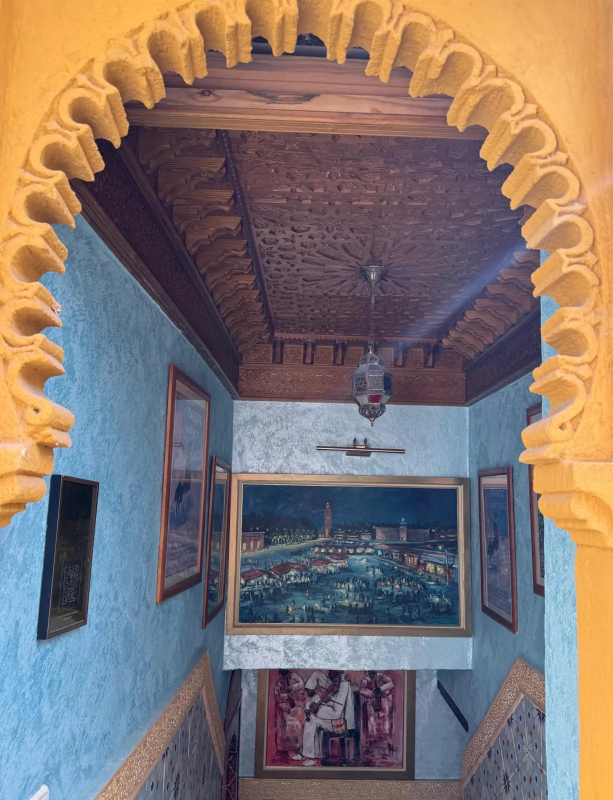 L’escalier bleu vu sous un arc de plâtre sculpté, plafond en cèdre