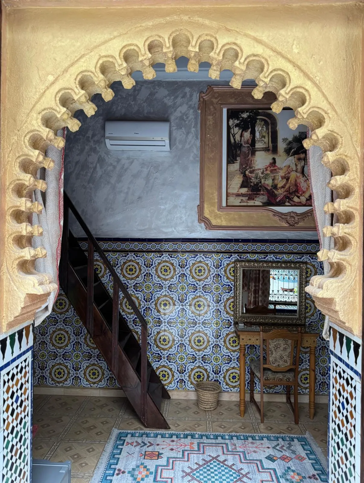 Un arc de plâtre sculpté, l’escalier en bois et le zellige