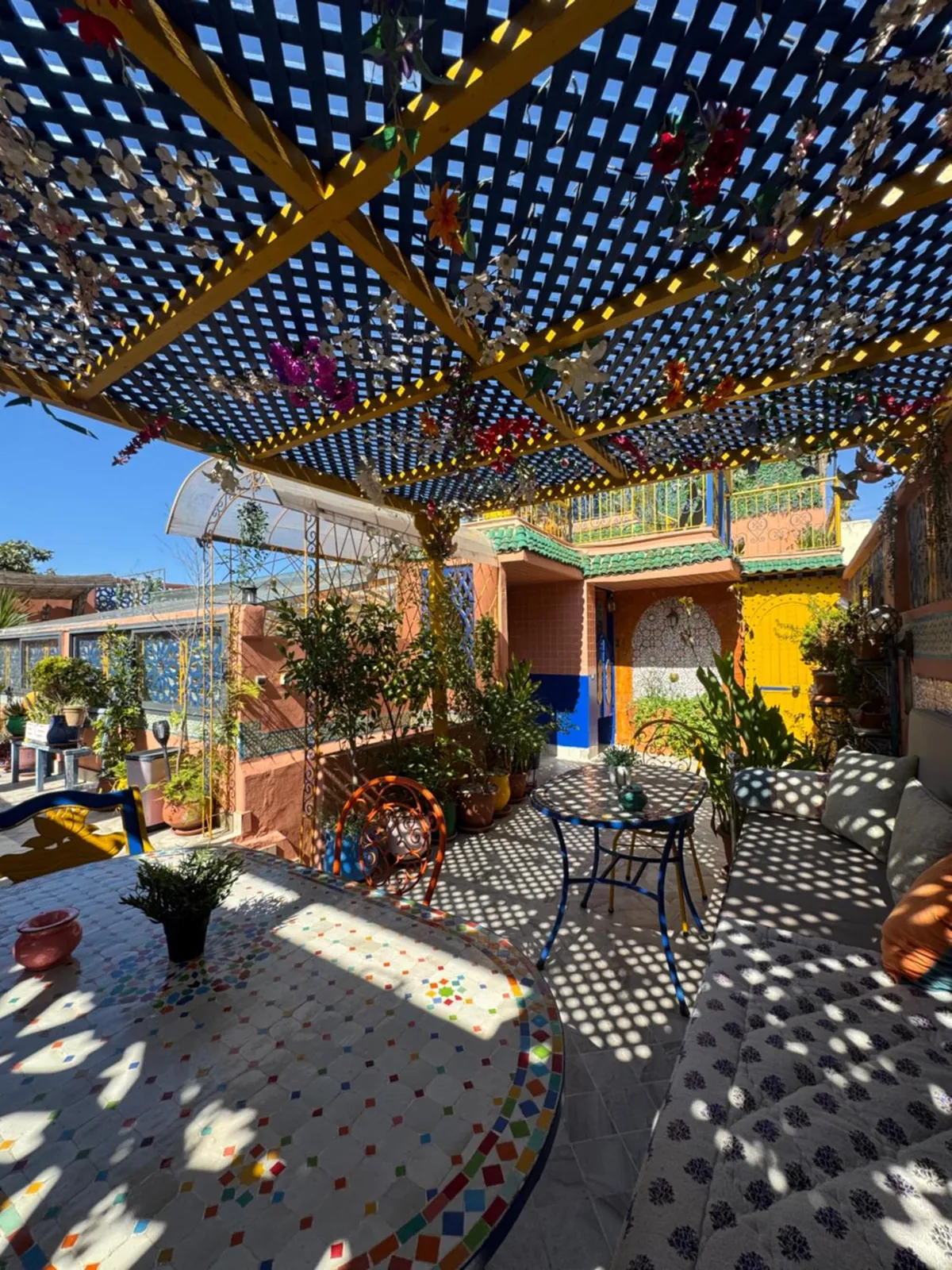 Le rooftop sous la pergola en treillis, son ombre en damier sur le sol